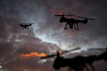 Innovation concept. Silhouette of drone flying on sunset. Heavy lift drone photographing