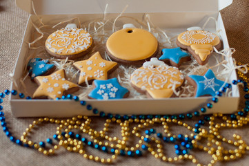 Beautiful christmas set of different holiday gingerbread cookies in present box and yellow, blue beads