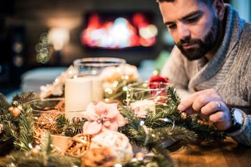 Bearded man decorating christmas table