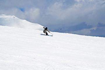 the skier descends from the slope in the clouds
