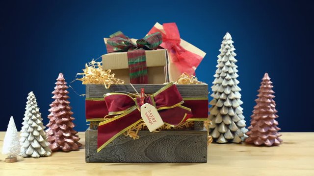 Stacking large English style traditional Christmas hamper with paper wrapped gifts and food, time lapse.
