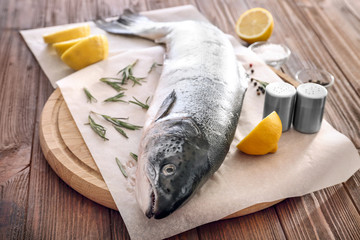 Board with fresh raw salmon on wooden table