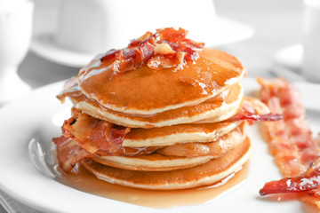 Tasty pancakes with bacon on plate