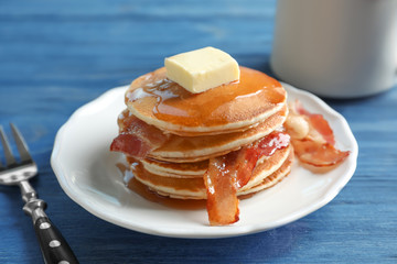 Tasty pancakes with bacon on plate