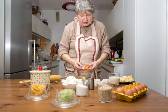 Oma trennt Eiweiß vom Eigelb. Sie backt Weihnachtskekse für ihre Enkel