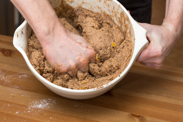 Mann mischt die Kekszutaten mit den H&auml;nden in einer Sch&uuml;ssel zusammen