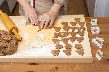 Viele fertig ausgestanzte Plätzchen auf einem Holzbrett, Draufsicht