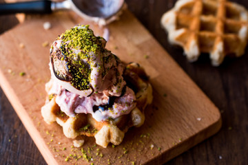 Belgium Waffle with ice cream on wooden surface.