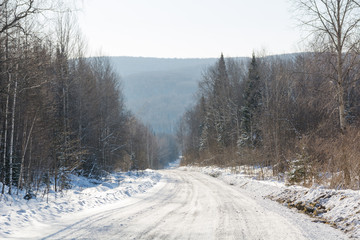 Fototapeta premium The winter road in the wood. The road in Siberia in the winter.