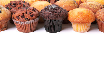 Muffin chocolate chip cup cake or cupcake various flavor several lots many in a row line top border isolated on white background photo