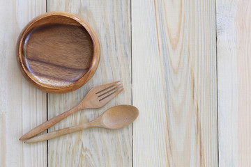 Wooden bowl and wooden spoon on wood background.