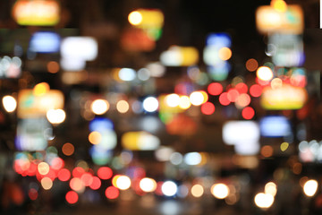 Blurry background of road with roaming cars at night.