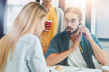 Cooperated skilled marketing experts analyze information in office. Bearded male speaks with...