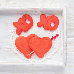 Red velvet pancakes with xo sign, hugs and kisses, and heart on wooden tray, top view, square