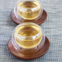Herbal rosemary tea in glass cup on oriental background, square format
