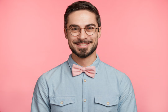 Delightful attractive male with mustache and beard dressed in festive clothes, happy to come on friend`s wedding, likes to participate in funny competitions or say toast, glad be photographed