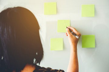 Entrepreneur Woman putting his ideas in Post-it planning on new business project