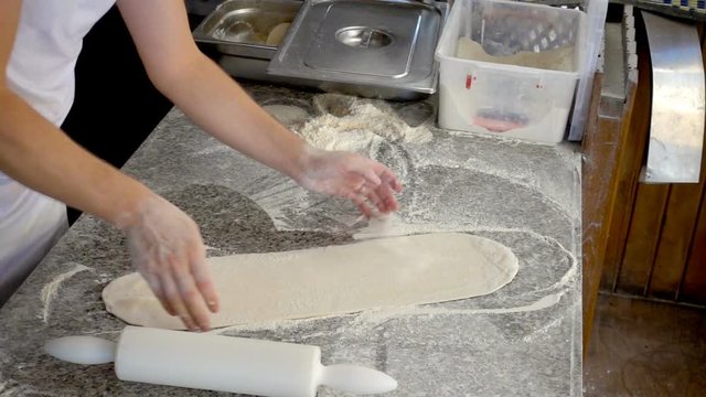 professional baker tosses raw very thin dough, slow motion