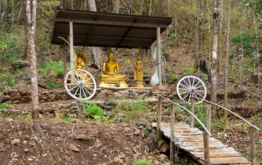 The Buddha is in the middle of the forest on the mountain and has a wooden bridge for the walk to worship.