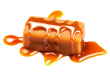 Sweet Caramel sauce flowing on caramel candies, isolated on white background.