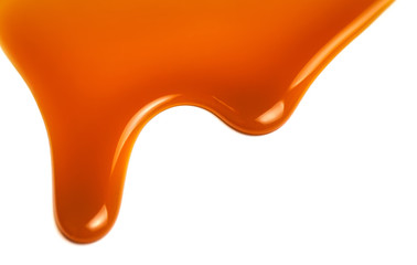 Sweet caramel sauce isolated on white background close up. Golden Butterscotch toffee caramel...