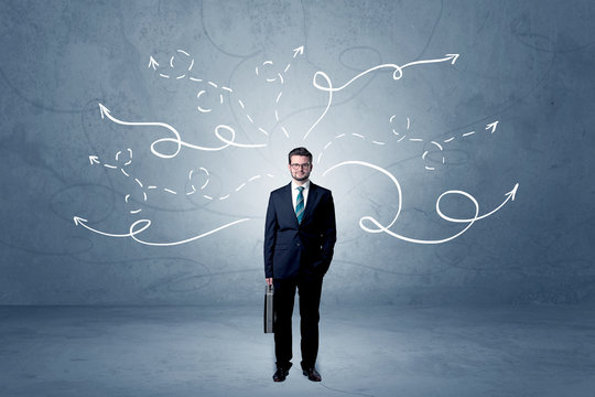 Businessman standing with winding arrows around