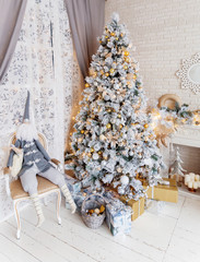 Christmas and New Year Eve Tree. Holiday winter background. Interior details - mirror-snowflake, mantelpiece with garland of light bulbs, many presents and elf with gifts.