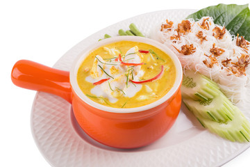 Curry crab, Seafood with Yellow curry sauce in orange ceramic pot, Isolated on white background