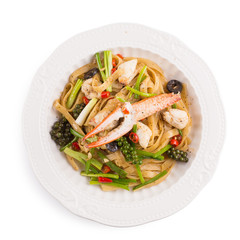 Spicy Seafood Spaghetti on a white ceramic dish isolated on white background