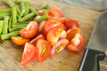 red ripe tomatoes sliced on cutting board for cooking in closeup