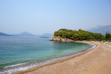 A deserted sandy beach among the beruze water.
