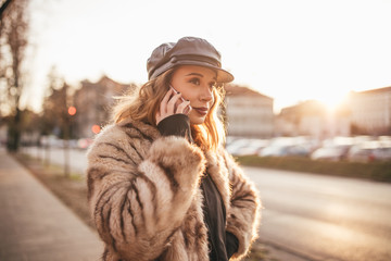 Stylish girl talking on her cell phone on her bike on city street