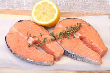 fresh raw salmon with spices and lemon on wooden cutting board. ready for cookin