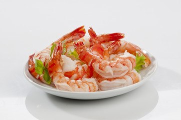 Steamed Jumbo headless shrimps with deli leaves and Lemon on white plate on white background 