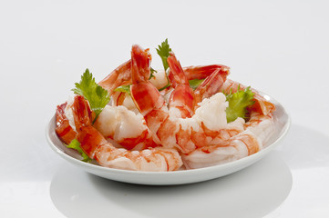 Steamed Jumbo headless shrimps with deli leaves and Lemon on white plate on white background 