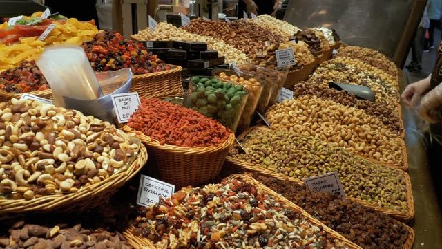 Large Counter of Dried Fruits and Nuts at a Farmers Market in La Boqueria. Barcelona. Spain. Nuts, dry fruits on display at the market on the showcase. Stall with Various dried fruits at Mercat de