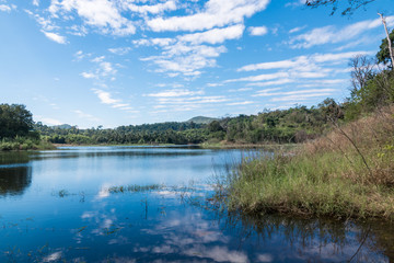 Fototapeta na wymiar Beautiful white clouds against the blue sky is mirrored in the water. Landscape with lake in sunny day,Thailand.