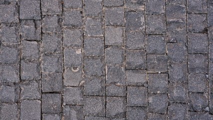 Top view of wet pathway paved with brick stones. Ancient design floor. For background and texture. 
