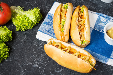 Hot dog with pickles and lettuce on concrete background