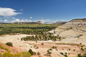 Fototapeta na wymiar Sugarloaf dome and green fields of Boulder, Utah, surrounded by white slopes of Durffey Mesa Grand Staircase - Escalante National Monument