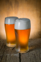 Beer in frosty mugs on rustic background