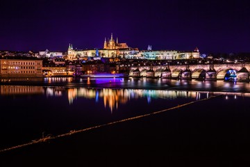 The view from the river Vltava at Charles Bridge and Prague Castle at night