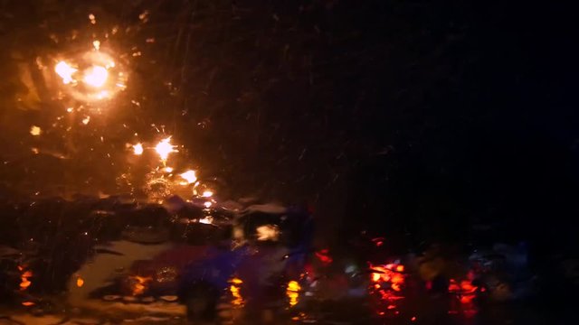 Night city road in rain. Wet glass car interior.