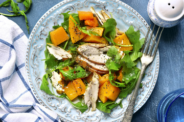 Pumpkin salad with chicken and arugula.Top view.