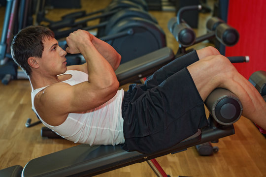 Young  man trains the abdominal muscles