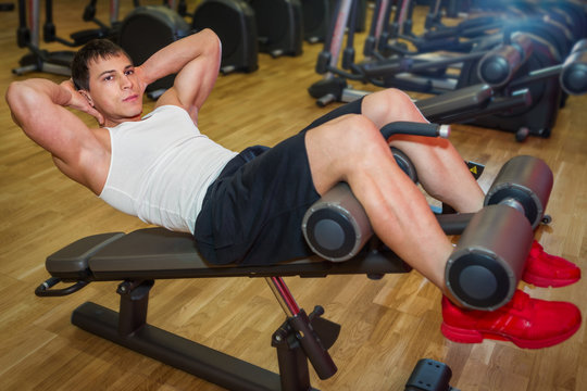 Young  man trains the abdominal muscles