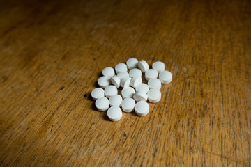 Fototapeta na wymiar Handful of small white vitamin K2 tablets