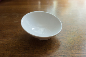 Pure white empty porcelain bowl on wooden table