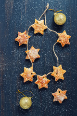 Obraz na płótnie Canvas Christmas cookie on a string in the form of a star on a wooden background.