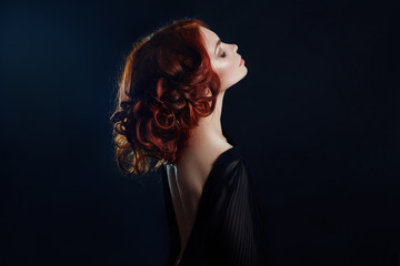 Beautiful woman with red hair on a black background. Portrait of a successful woman, pure skin,...